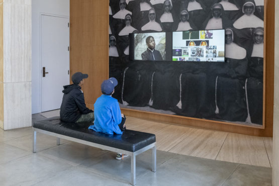 Visitors at Stanford’s Cantor Arts Center absorb the video images from Kahlil Joseph’s BLKNWS, 2018.