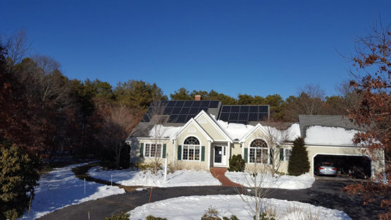 House with solar panels surrounded by snow.