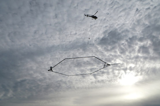 A helicopter flies over farmland near Tulare