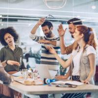 group of coworkers around a table in animated discussion