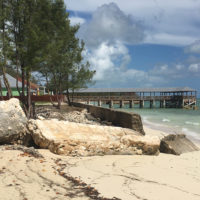 broken shoreline protection in the foreground; restaurant pier in the background