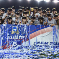 Cardinal women's soccer team with campionship banner