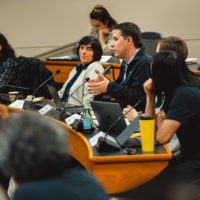 Jeremy Weinstein speaking with other members of the Faculty Senate looking on.