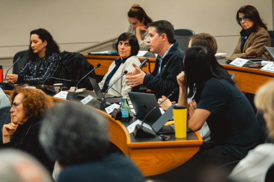 Jeremy Weinstein speaking with other members of the Faculty Senate looking on.