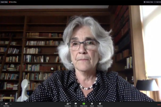 Persis Drell in front of library shelves