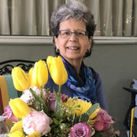 Judith Haccou at a table with bouquet of flowers