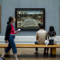 people in an art museum looking at paintings