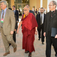 James Doty, left, director of Stanford's Center for Compassion and Altruism Research and Education, and the Rev. Michael Engh, right, president of Santa Clara University, escort the Dalai Lama to Monday's conference on commerce, ethics and compassion.